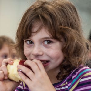Wednesday September 17th, 2014 Manchester Elementary, Save the Children after school program, Healthy Choices: First grader, Brooklyn, 7 enjoys an apple for a snack in her after school program.